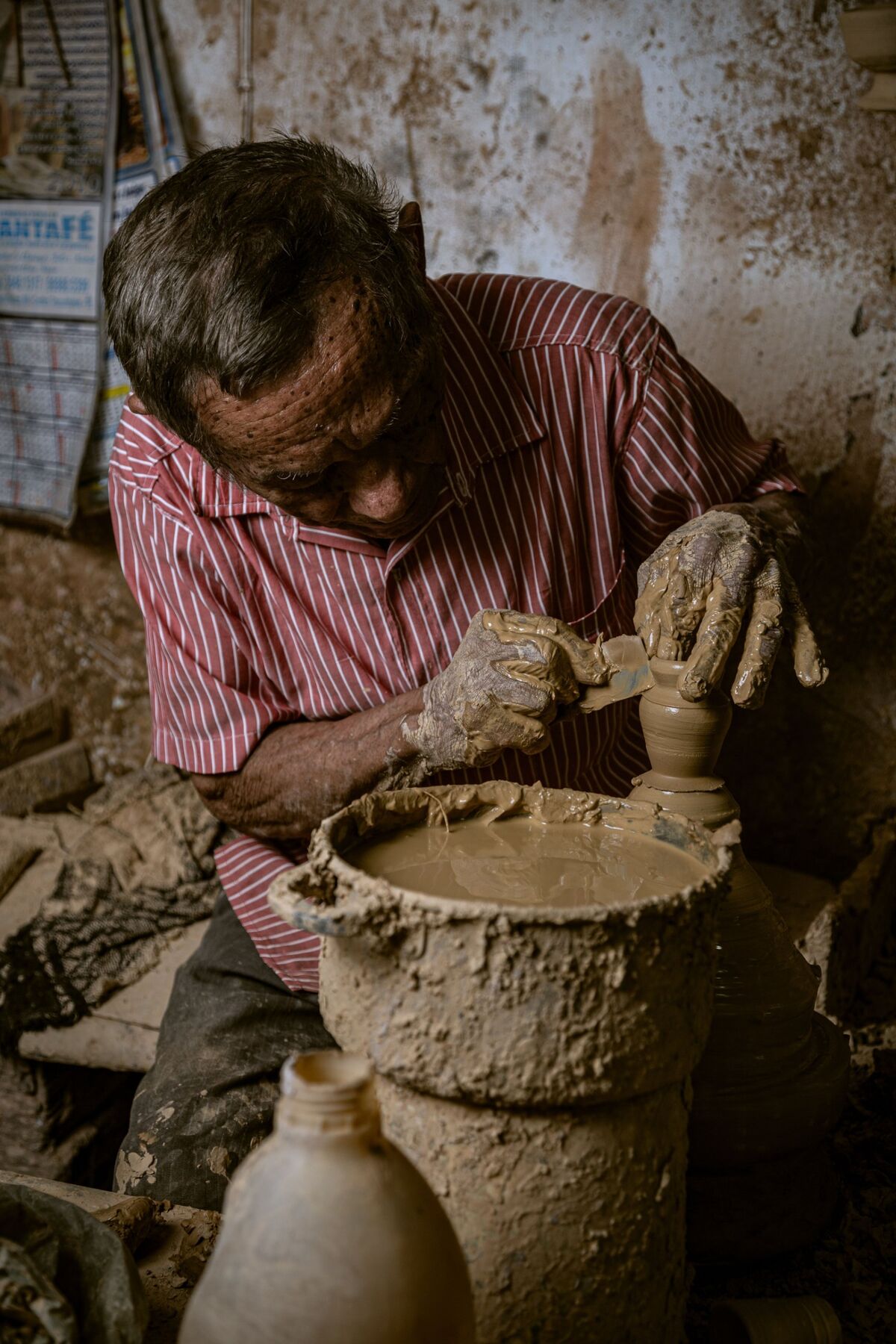 Oleiro moldando um grande pote de barro